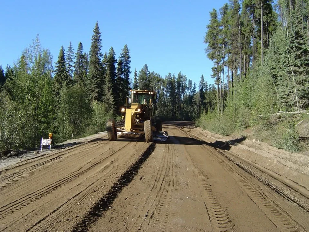 Heavy equipment maintaining logging road